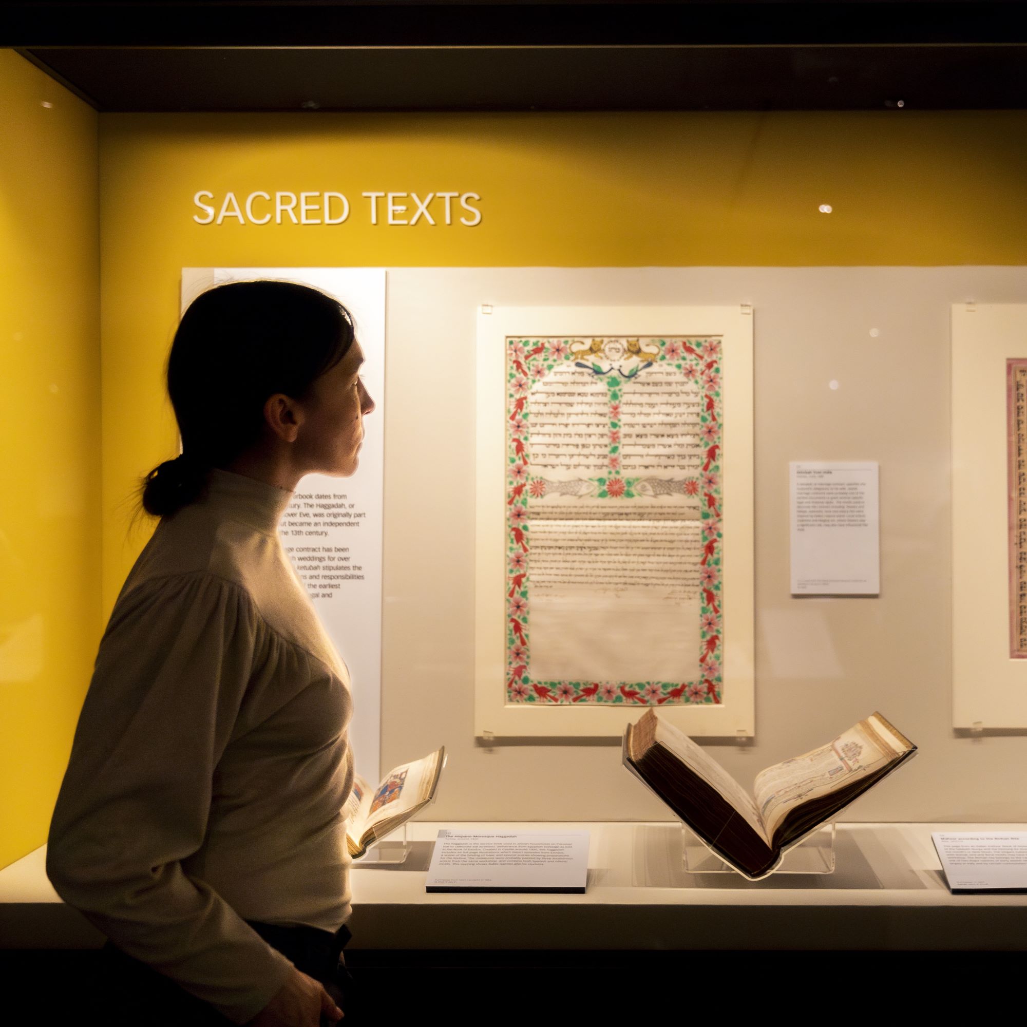 A woman looks at sacred texts in the treasures gallery 