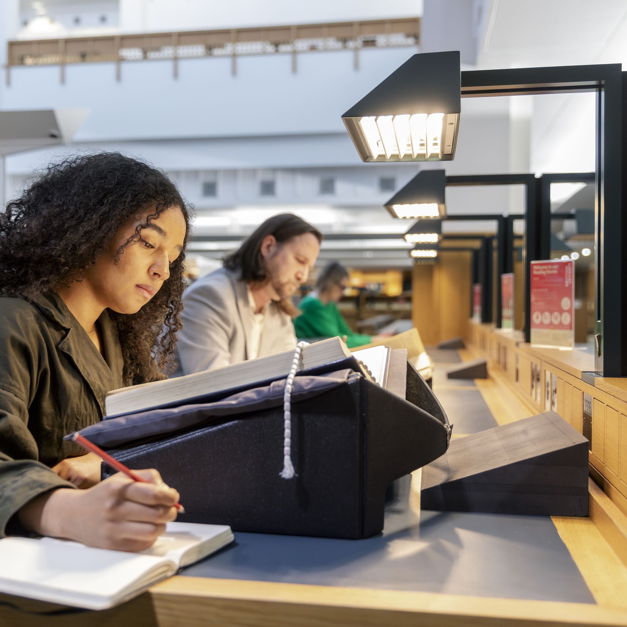 A woman sits at a desk in the Library Reading Room 