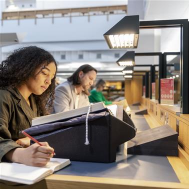 A woman sits at a desk in one of the Library's Reading Rooms 