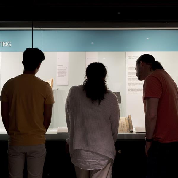 A group of people look at the Printing display in the Treasures Gallery 